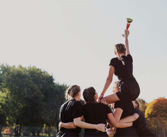 back-view-female-team-winning-trophy